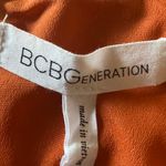 BCB GENERATION-SUMMER DRESS WITH CUTOUT-SIZE 2 Beautiful orange rust color dress, elastic waist, front cutout, back zipper, 100% polyester, excellent condition Measurements: Bust: armpit to armpit 16 inches Waist: side to side 14 inches Length: shoulder seam to bottom 32 inches Photo 5