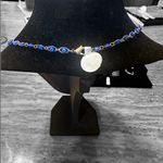 Elegant gold tone and blue evil eye necklace. Photo 1