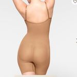 SKIMS SEAMLESS SCULPT MID THIGH BODYSUIT, in the color tan ochre. Photo 3
