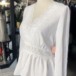Rose & Grey LOS ANGELES white lace V-neck long sleeve shirt top peplum tie cuff  New with tag  Smoke and pets free  Same day shipping Elevate your wardrobe with this stunning white lace blouse from . The V-neckline and long sleeves add a touch of elegance to this top, while the peplum and tie cuff details create a flattering silhouette. The angel character and rose theme make it perfect for any occasion, from casual outings to formal events.   Crafted from high-quality lace fabric, this blouse features adjustable features and is available in size S. The solid pattern and delicate lace accents make it a versatile piece that can be paired with any bottom. Whether you're dressing up or down, this  blouse is sure to turn heads. Photo 1