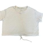 American Eagle cropped drawstring waist short sleeve top in excellent condition.  Size small  Measurements: armpit to armpit 23” length 18” Tan/cream Short sleeve  Cropped  Relaxed, oversized fit  Drawstring waistline  Ribbed fabric  Soft and thick fabric Photo 0