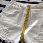 Mid/High waisted white denim shorts with frayed hem and raw hem, zipper and button closure. Size XS Photo 4