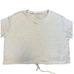 American Eagle cropped drawstring waist short sleeve top in excellent condition.  Size small  Measurements: armpit to armpit 23” length 18” Tan/cream Short sleeve  Cropped  Relaxed, oversized fit  Drawstring waistline  Ribbed fabric  Soft and thick fabric Photo 1