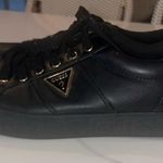 Guess Beautiful black and gold flat tennis shoes size 9 with gold triangle logo Photo 3