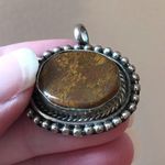 Antiqued silver tone pendant with oval shaped variegated brown stone Photo 0