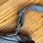 Gray studded faux leather cross body bag. Magnetic snaps on the front. Photo 3