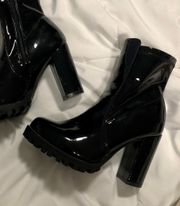 Leslie-50 black patent leather booties.