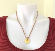 yellow jade circle bead on a tan faux leather chord necklace gold tone toggle