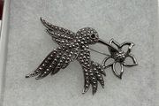 Vintage silver colored feeding hummingbird