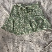 Green and white floral pattern flowy skort with a tie belt. 