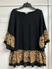 Black with Cheetah print bottom and sleeve ruffle detail. Size medium