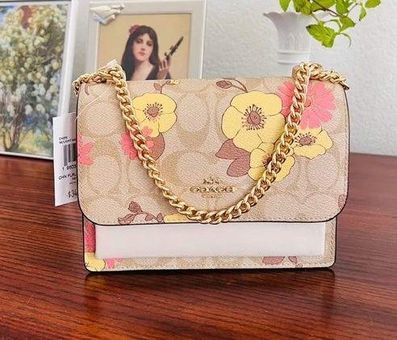 Woman holding brown and pink floral leather crossbody bag photo