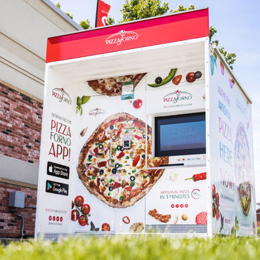 An outdoor PizzaForno kiosk that is located beside a gas station
