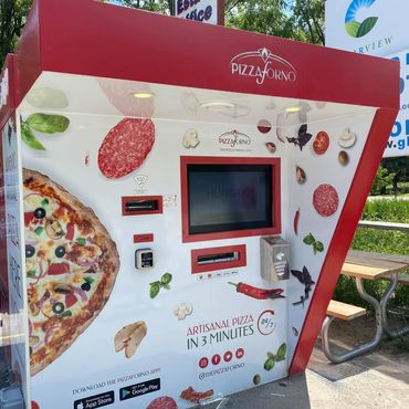 An outdoor PizzaForno Kiosk in a parking lot