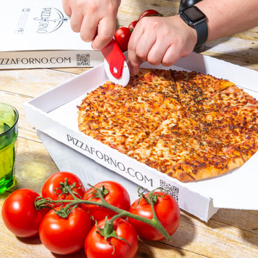 A person cutting a cheese pizza into eight slices.