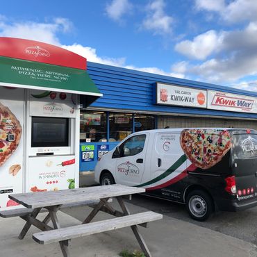 An outdoor PizzaForno kiosk with a branded PizzaForno van parked beside it