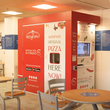 An indoor pizza vending machine located in a cafetaria