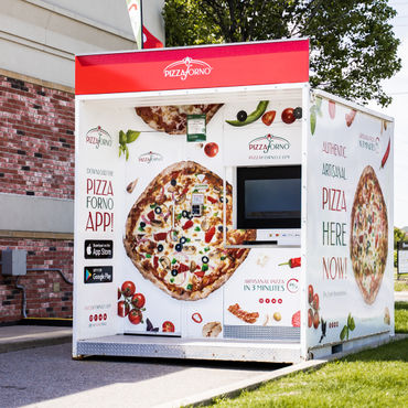 A picture of a pizza vending machine that is outside in a parking lot