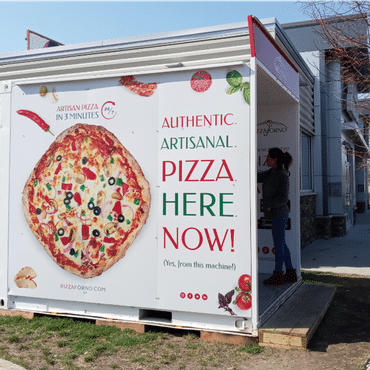 A side view of a pizza vending machine with the sunlight hitting it