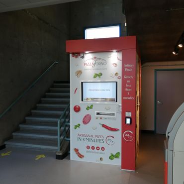 An indoor pizza vending machine located in a university stairwell
