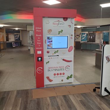 An indoor PizzaForno pizza kiosk that is inside an office building