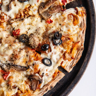 A Vegetarian pizza on a black cutting board