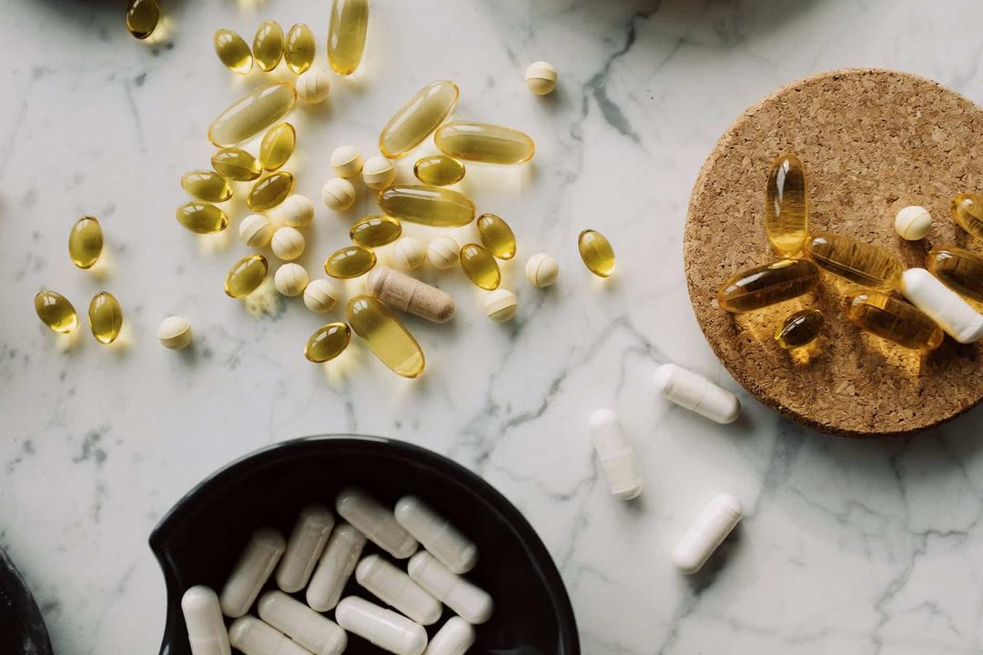 variety of capsules and dragees on white marble countertop in studio, thuốc giảm cân có thật sự hiệu quả, thuốc giảm cân, hiệu quả của thuốc giảm cân,