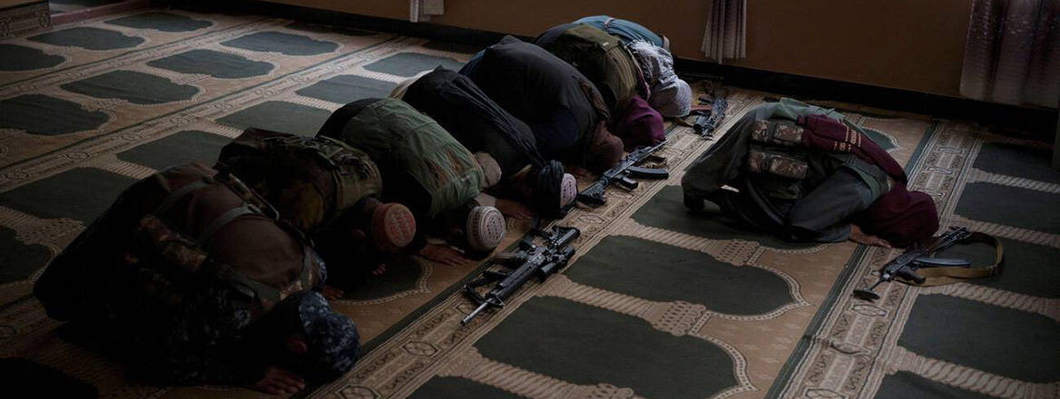 Taliban members lay their weapons down as they pray inside a mosque in Kabul, Afghanistan, September 2021. Courtesy of AP Photo / Felipe Dana / Alamy