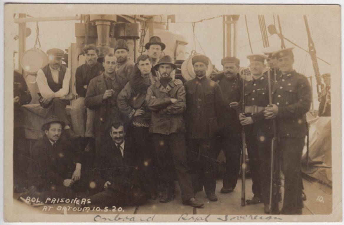 Bolshevik or communist prisoners standing next to British military personnel on board HMS Royal Sovereign, Batoum, May 1920