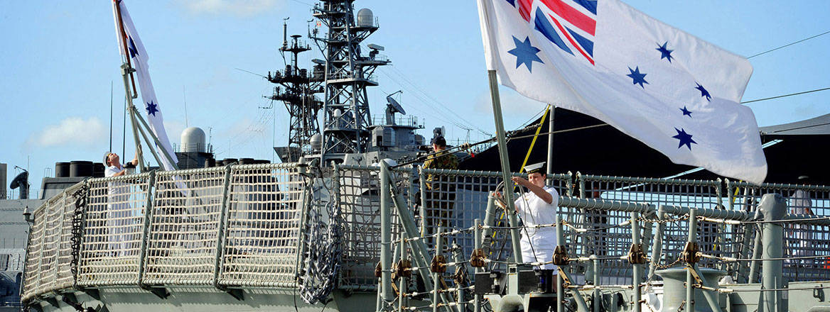 Setting sail: Australian sailors raise the colours aboard the HMAS Darwin and the HMAS Perth during an exercise in the Pacific