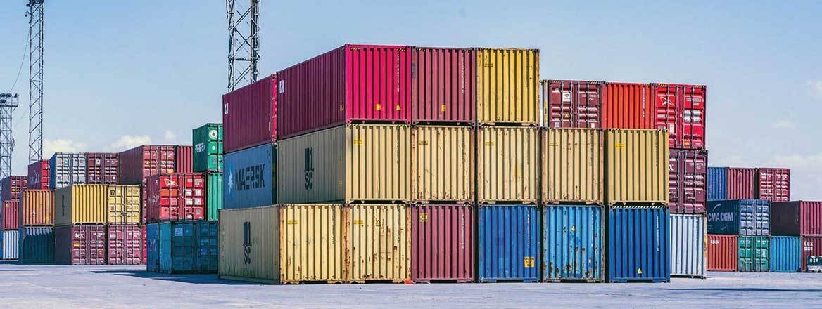 Stacks of different coloured containers on grey concrete