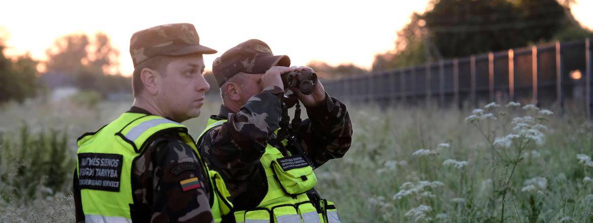 Two border guards in a field near Adutiskis, Lithuania, 15 June 2021.