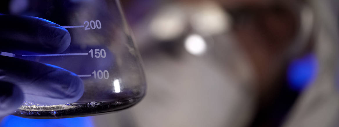 A chemist holds up a test tube with liquid