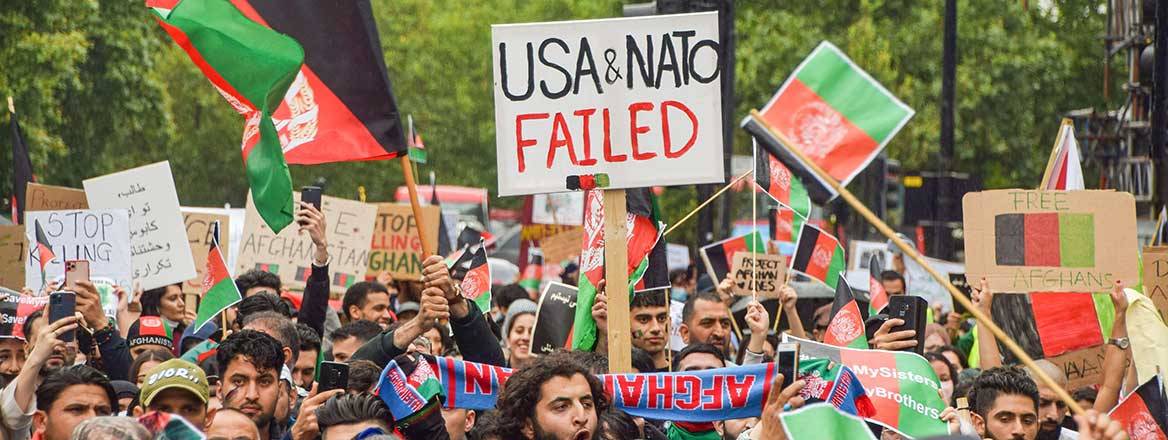 A large crowd of demonstrators holding signs and flags.