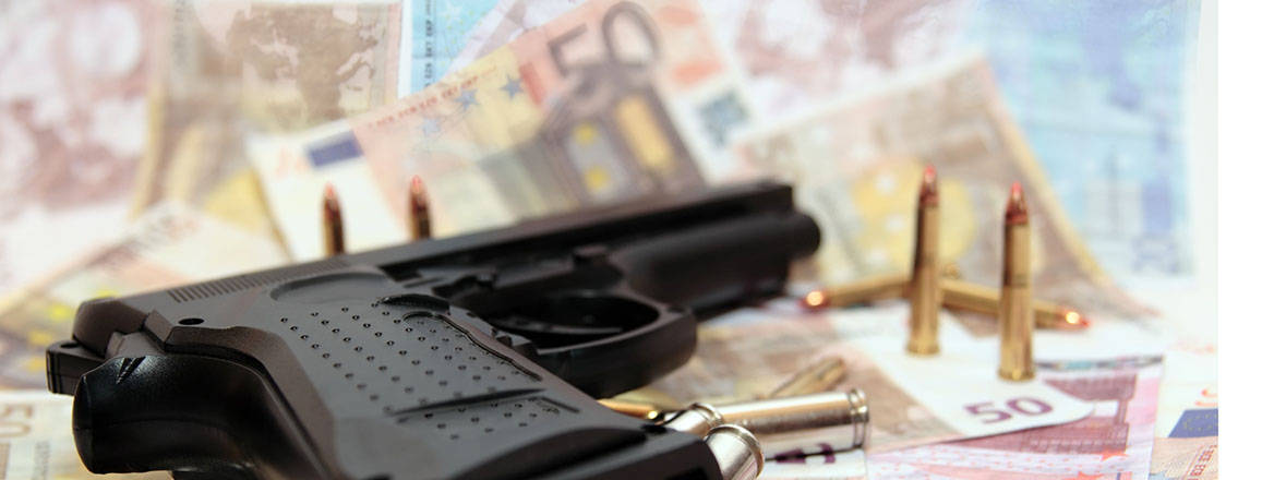 gun and bullets lying on euro notes