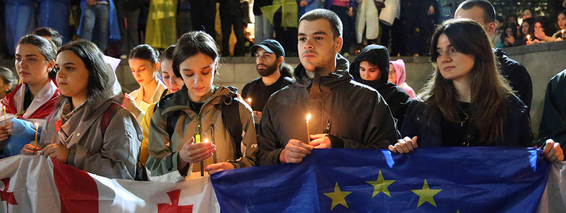 Burning hope: demonstrators hold Georgian and EU flags in Tbilisi on 3 May 2024