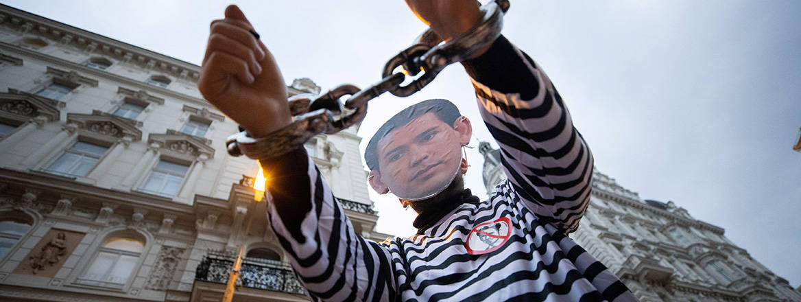 A demonstrator dressed as Sebastian Kurz in prison clothes and handcuffs takes part in a protest in Vienna on 7 October 2021