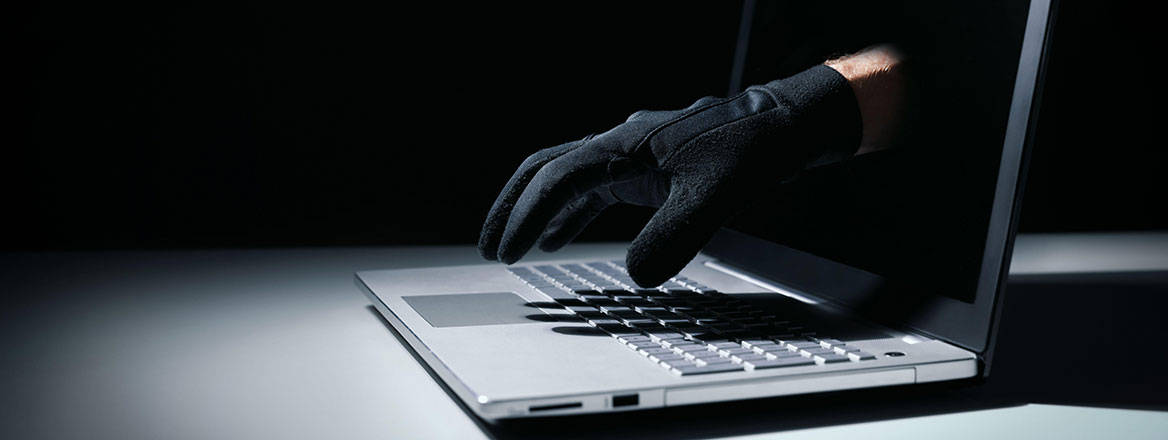thief's hand reaching out of laptop