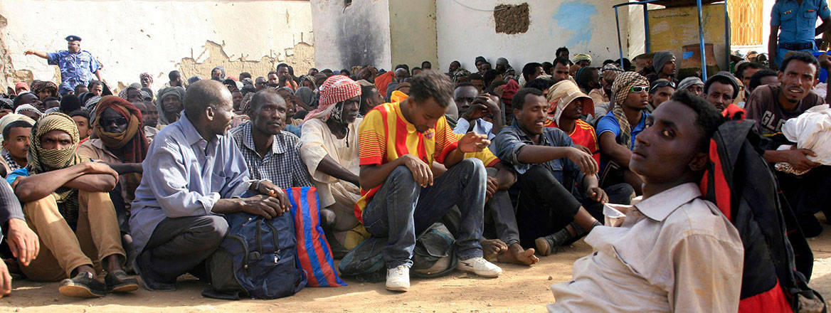 Little respite: migrants abandoned by traffickers in the desert wait inside a military base after being located by Libyan and Sudanese forces