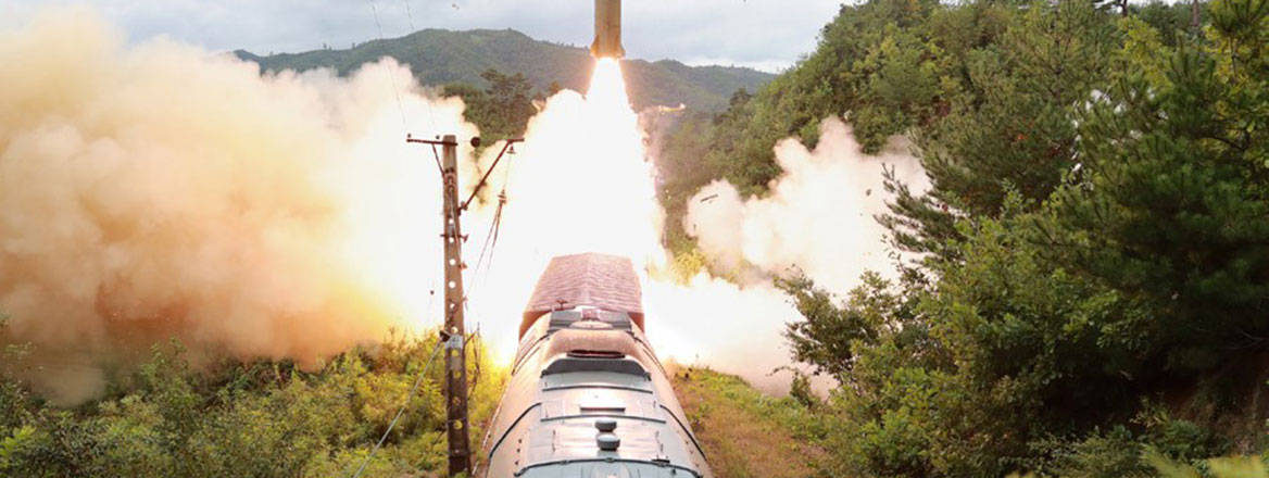 Missile shortly after launch with a train in the foreground.