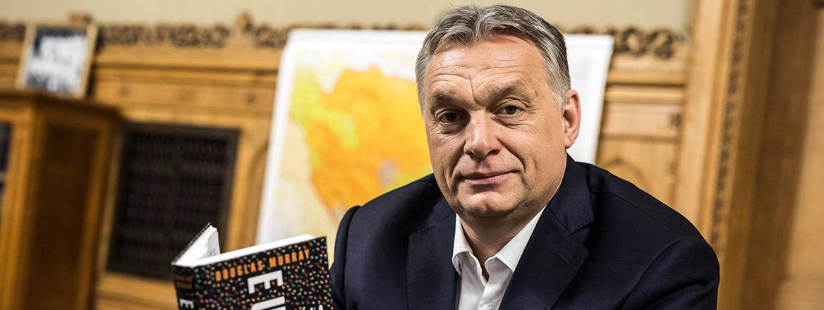 Hungary's Prime Minister Viktor Orbán holding a copy of The Strange Death of Europe by Douglas Murray. A map of Bosnia and Herzegovina can be seen in the background