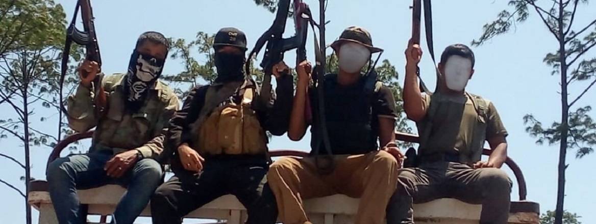 Professional killers on top of an improvised cladded armour vehicle showing off their rank as ‘masters’ or elites of the turf.