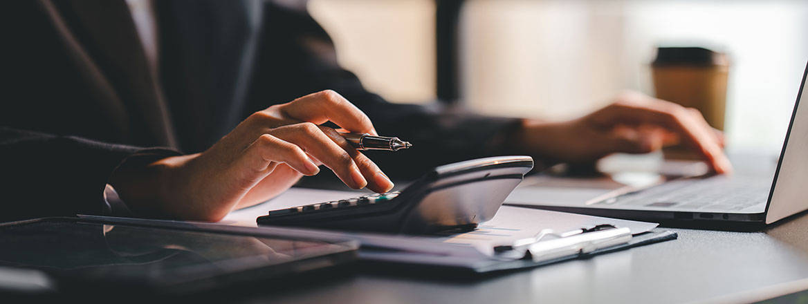 Person using calculator and laptop