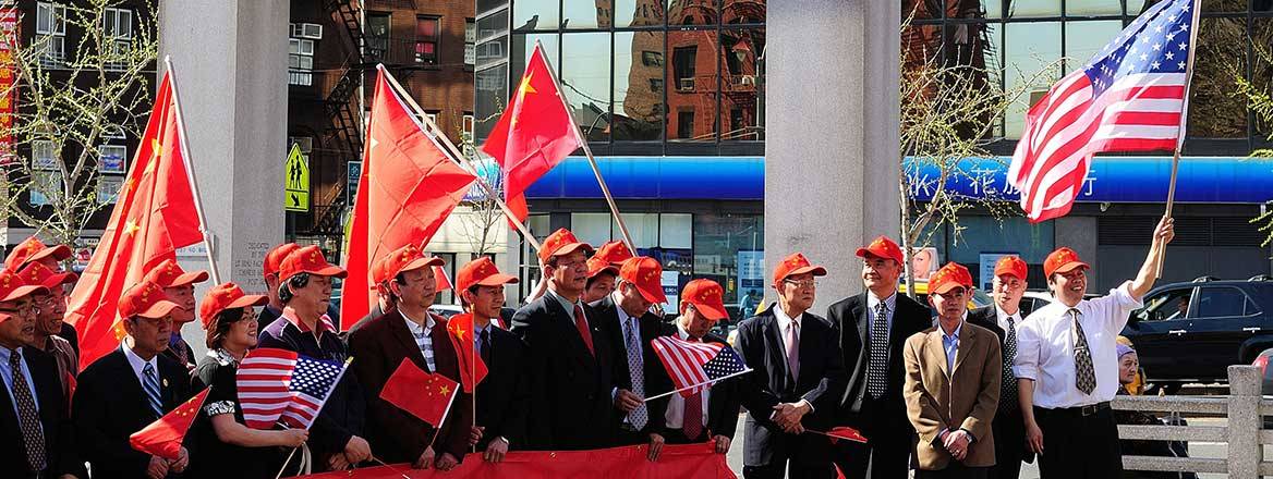 Group of people holding Chinese and US flags