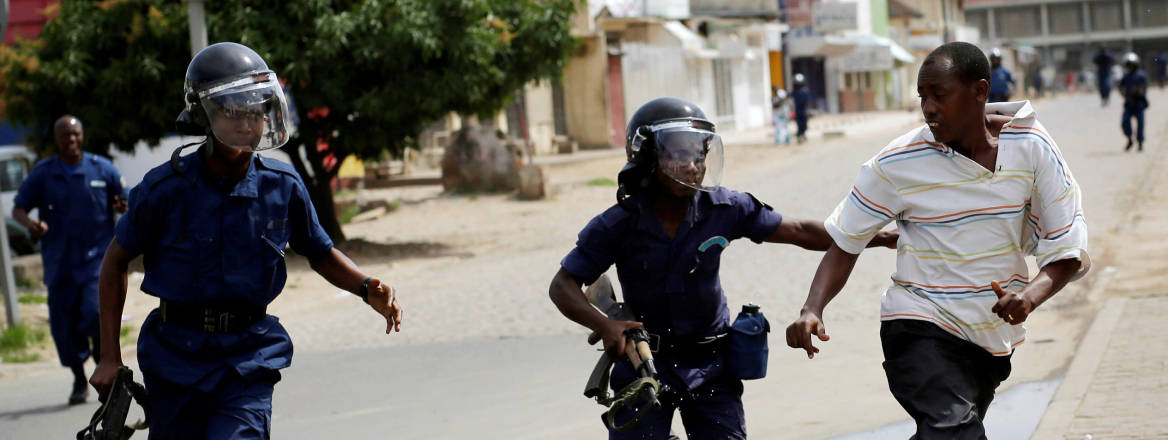 riot police chase demonstrator in Bujumbura, Burundi