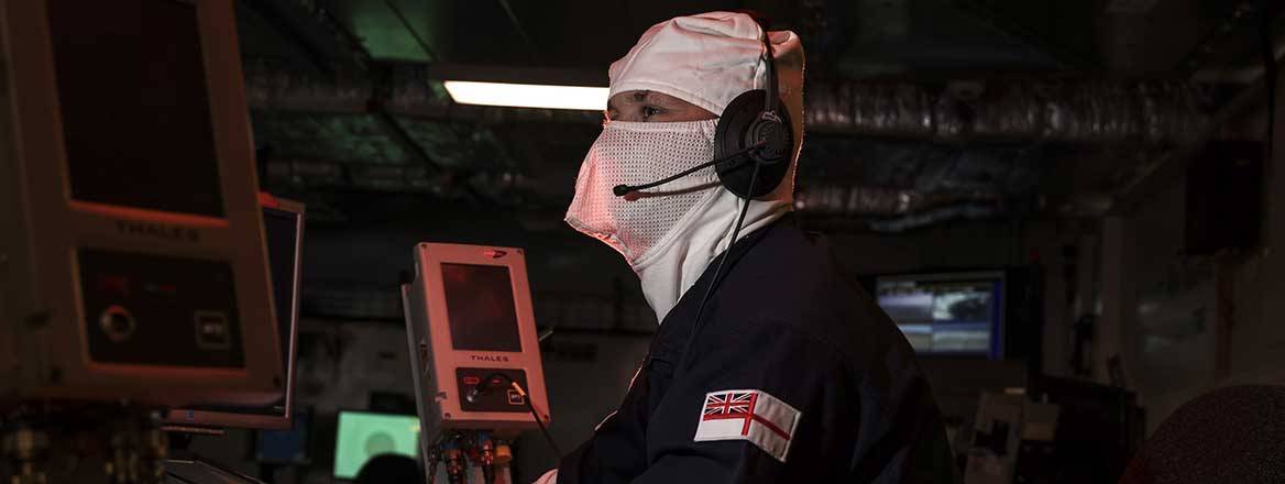 Royal Navy personnel at a desk wearing flash gear.