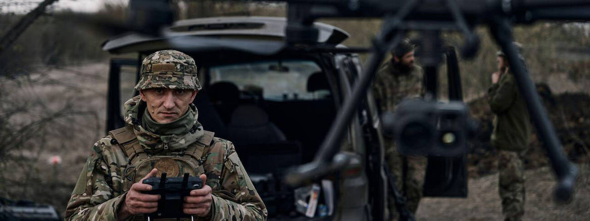 A Ukrainian soldier launches a drone in woodland