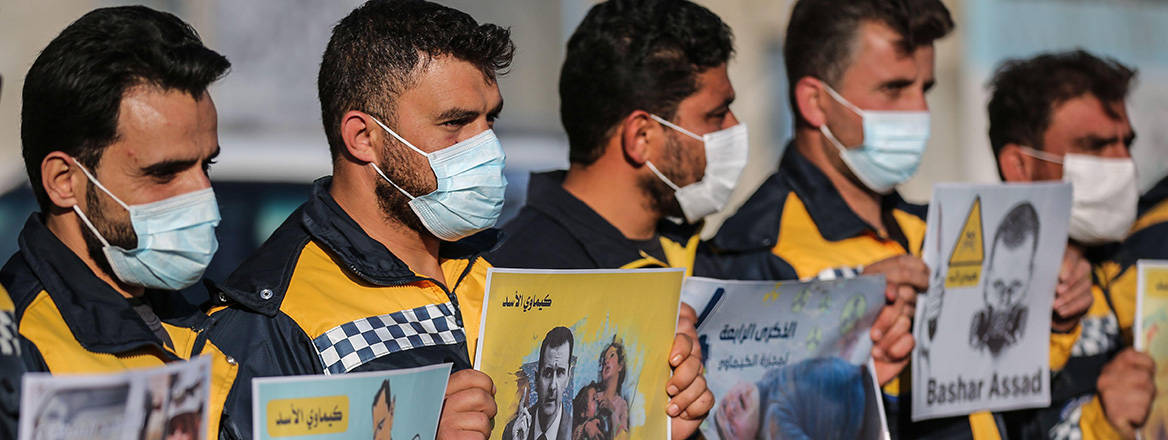 United in grief: Syrians hold placards during a protest to mark the anniversary of the alleged chemical attack in Khan Shaykhun