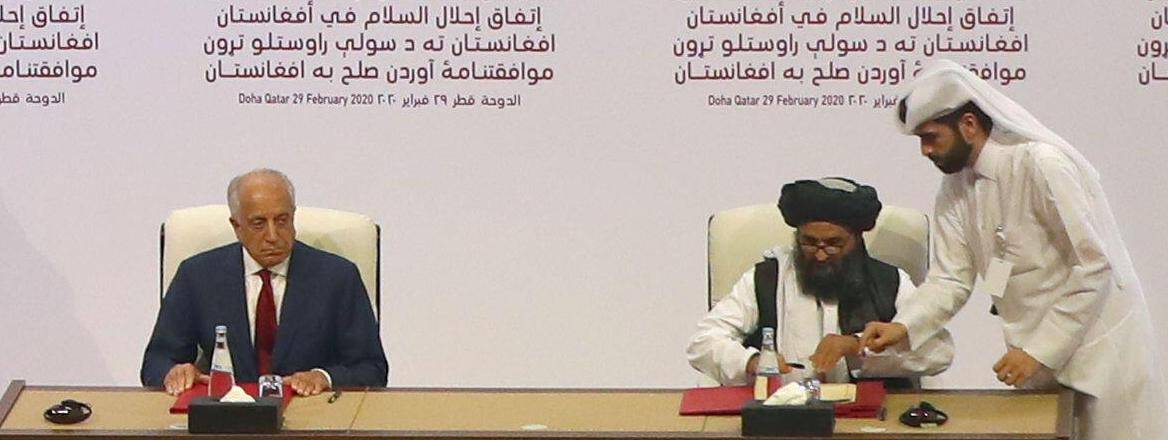 Mullah Abdul Ghani Baradar, the leader of the Taliban delegation, signs an agreement with Zalmay Khalilzad, U.S. envoy 