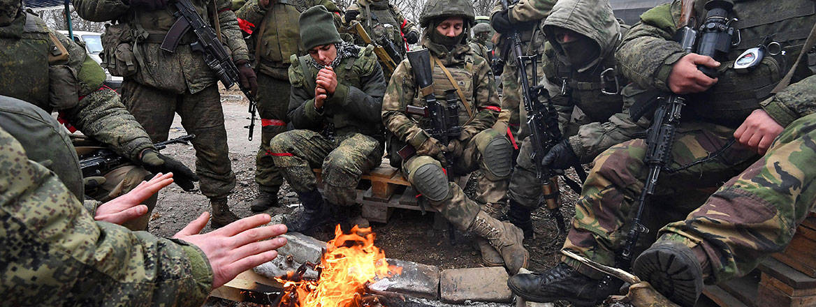 Fighting the cold: Russian soldiers rest by a fire in the city of Nikolaevka in March 2022. Image: Sipa US / Alamy